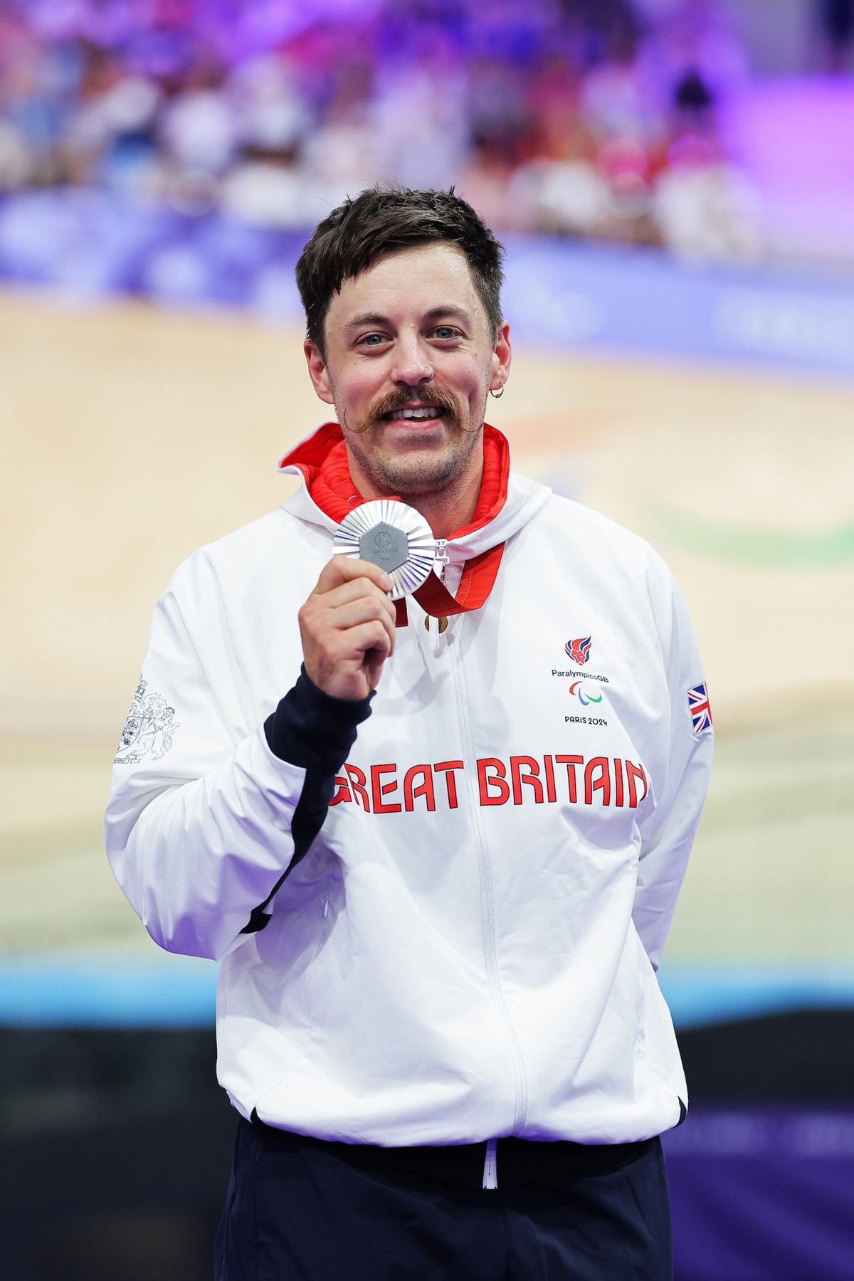 Blaine Hunt holding his Paralympic silver medal on the podium, Paris 2024